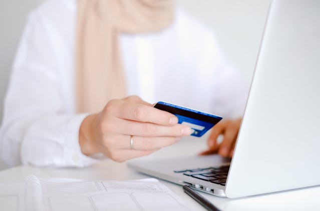 a person holding a credit card for an online payment